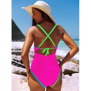 Détail du maillot de bain bicolore avec tissu rose vif et bretelles croisées vert fluo