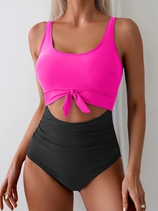 Detail of high-waist cutout swimsuit with pink front-knot top and ruched black bottom