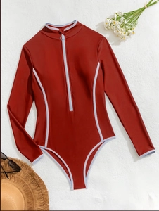 Detail of red long sleeve surfing swimsuit with white trim and front zipper closure