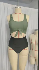 Detail of olive green knot front bikini top with black high waist bottom on mannequin