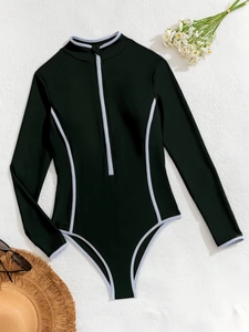Flat lay of long sleeve black surf swimsuit with white piping and zipper detail