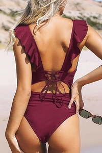 Detail view of burgundy floral swimsuit featuring ruffled straps and back lace-up design