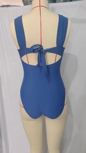 Detail view of the blue one-piece swimsuit featuring a back cutout and stylish bow-tie closure
