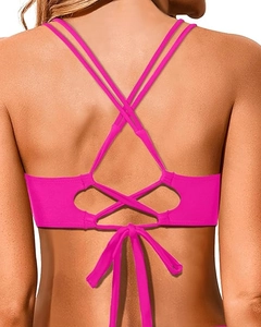 Macro view of bright pink bikini top with crisscross back straps and tie-up bow detail
