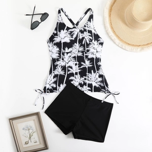 Flat lay of a two-piece tankini set with palm tree prints and high waisted shorts