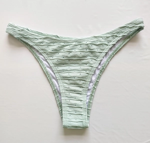 Detail of mint green bikini bottom with textured seersucker fabric and wave patterns