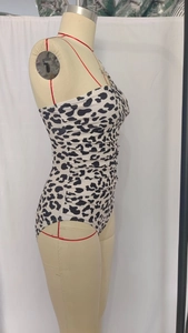 Detail view of the black and white leopard print and side ruching on the swimsuit