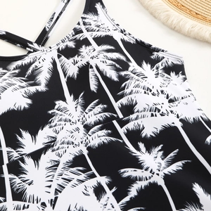 Detail of swimsuit top featuring white coconut palm tree silhouettes on black fabric