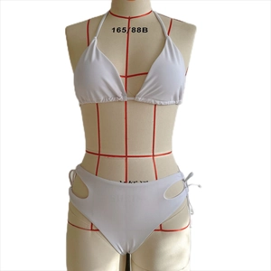 Détail du bikini blanc avec haut licou et découpes géométriques à la taille