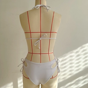 Détail du dos de bikini blanc avec liens licou et nœuds ajourés sur les côtés