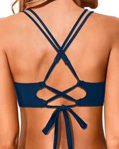 Detail of navy blue bikini top featuring crisscross back straps and a self-tie bow