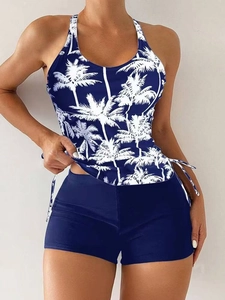 Detail of tropical palm print bikini top with cross-back straps and blue boyleg shorts