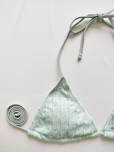 Detail of light green halter bikini top with ribbed texture and delicate tie straps