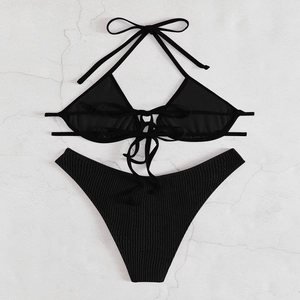 Detailed flat lay of black halter bikini set with textured ribbed fabric and ties