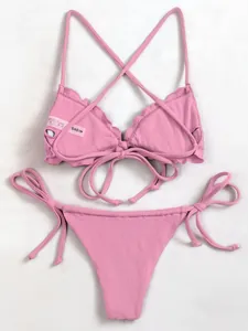 Detail view of pink ribbed bikini set with scalloped edges and cross-back tie design
