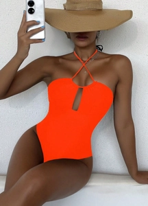 Detail of a bright orange one-piece swimsuit with halter neck and front cutout design