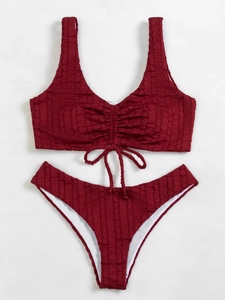 Macro detail of wine red ribbed bikini fabric showing high-quality bubble texture and drawstring
