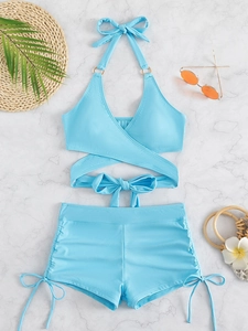 Flat lay of light blue two-piece swimsuit with halter top and high-waisted shorts