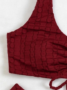 Detail of burgundy bikini top featuring honeycomb textured fabric and seamless stitching
