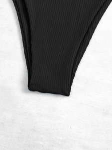 Close-up of black ribbed bikini fabric showing detailed texture and high-quality stitching