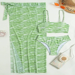 Flat lay of green zebra print bikini set with matching tie-waist long sarong and beach hat