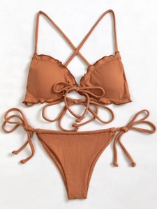 Flat lay of ribbed terracotta two-piece bikini set with ruffle trim and side ties