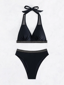 Sexy black halter bikini set with rhinestone trim and mesh panels on marble background