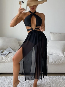 Detail of black halter swimsuit featuring gold ring accents and mesh skirt with high slit