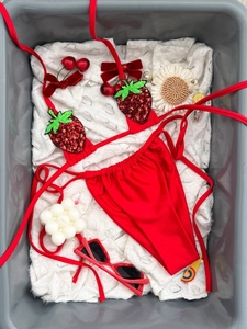 Bikini rosso con ricamo di fragole a paillettes presentato in un cesto decorativo