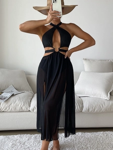 Detail of black bikini with gold metal ring and matching mesh cover-up skirt with high slit
