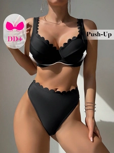 Dettaglio del top bikini push-up nero con bordi a conchiglia e supporto coppa DD+