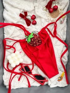 Dettaglio slip bikini rosso con laccetti e decorazione patch fragola in paillettes lucide