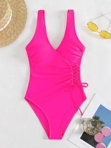Flat lay of hot pink one-piece swimsuit with V-neck and lace-up side details