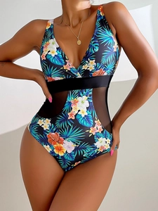 Detail of tropical floral print monokini with sheer black mesh cutouts and V-neckline