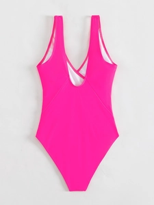 Flat lay of pink one-piece swimsuit featuring a deep U-back and cross-strap details