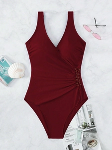 Flat lay of a burgundy one-piece swimsuit with V-neck and drawstring waist detail