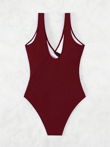 Detail view of the deep red one-piece swimsuit featuring a wide U-shaped open back design