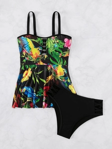 Détail du haut de tankini imprimé tropical avec lanières croisées noires et liens latéraux