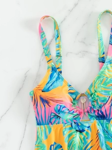 Detail of tropical print bikini top with rhinestone heart pendant and V-neckline