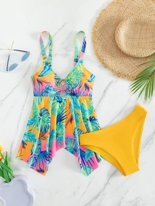 Flat lay of a tropical leaf print bikini top with metal ring and yellow high-waist bottoms