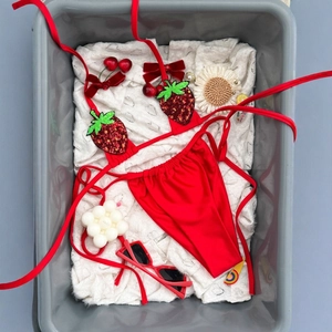 Bikini due pezzi rosso con applicazioni di fragole in paillettes e top a fascia nel cesto