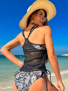 Detail of paisley print bikini set featuring black mesh vest and side tie swim bottoms