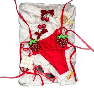 Bikini a due pezzi rosso con applicazioni di fragole in paillettes e slip classico con lacci