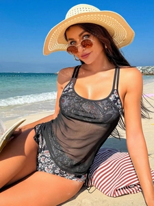Detail of sheer black mesh tankini top with tropical floral print bikini bottom