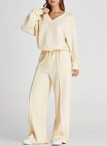 Detailed view of the V-neck sweatshirt and drawstring wide-leg pants in cream knit fabric