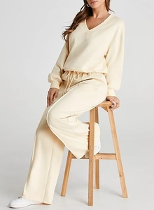 Macro detail of cream knit V-neck sweatshirt and drawstring high waist trousers set