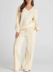 Detail of V-neck sweatshirt and drawstring wide-leg pants in cream knitted fabric