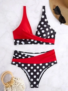 Two-piece bikini with red and polka dot contrast on a white marble background