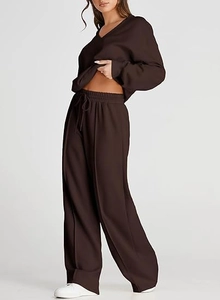Detail of dark brown V-neck sweatshirt and drawstring wide-leg pants fabric texture