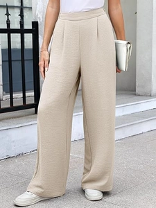 Close-up of high-waisted wide-leg crepe trousers showing textured fabric and pleat details